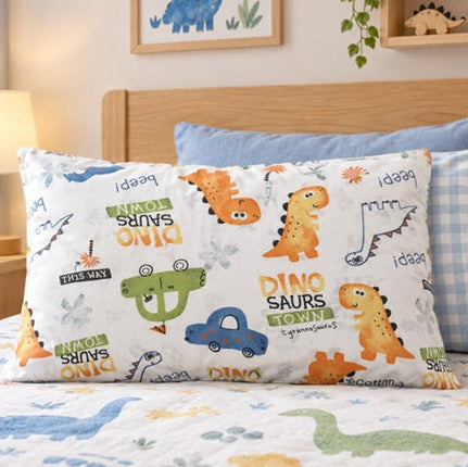 A children's pillowcase with a colorful dinosaur print, styled on a bed with a matching duvet cover in a cozy bedroom setting.