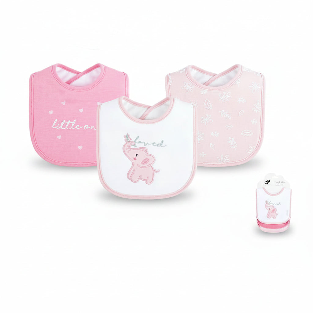 Three baby bibs in pink and white are displayed on a white background with product details text below. The set includes a pink bib with 'little one' text, a white bib with a pink elephant and 'loved' text, and a pale pink bib with floral patterns.
